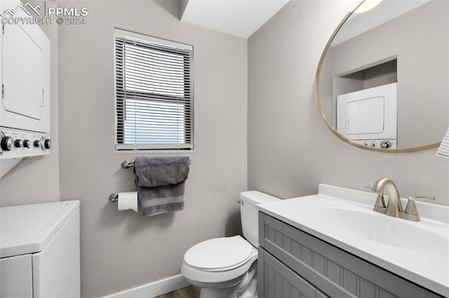 bathroom with vanity, toilet, and stacked washer / drying machine