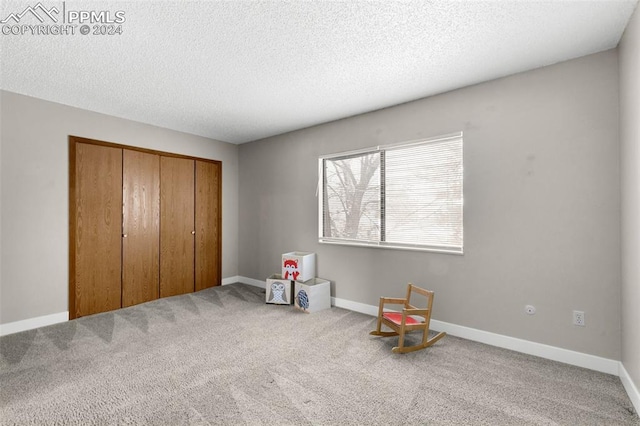 playroom featuring a textured ceiling and carpet floors