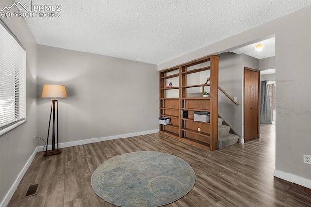 living area featuring dark hardwood / wood-style flooring and a textured ceiling