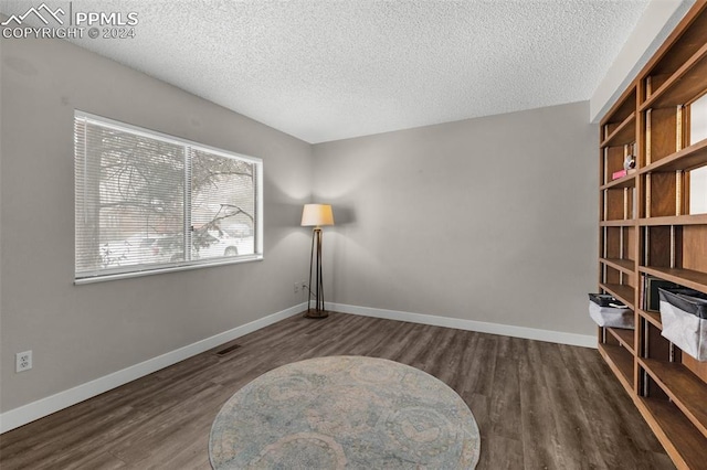 living area featuring a textured ceiling and dark wood-type flooring