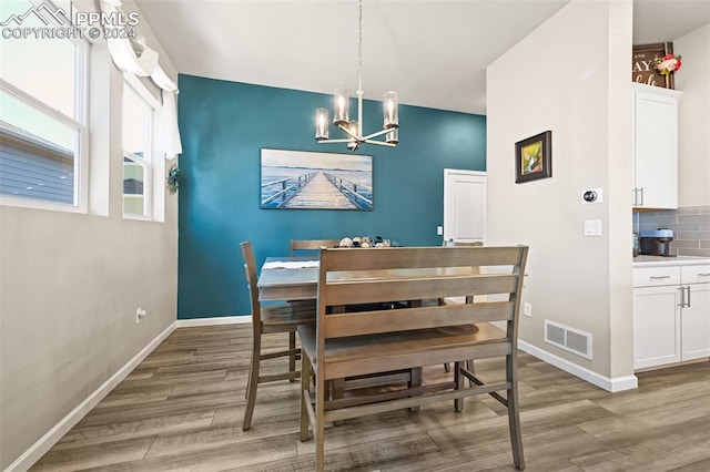 dining area with hardwood / wood-style flooring and a notable chandelier