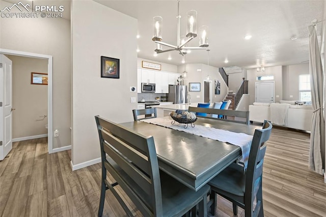 dining space featuring a notable chandelier and light wood-type flooring