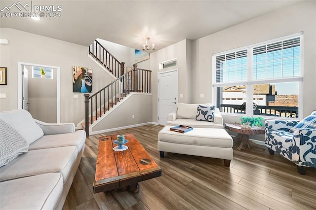 living room with dark hardwood / wood-style flooring and a notable chandelier