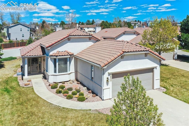 mediterranean / spanish-style house with a garage and a front lawn