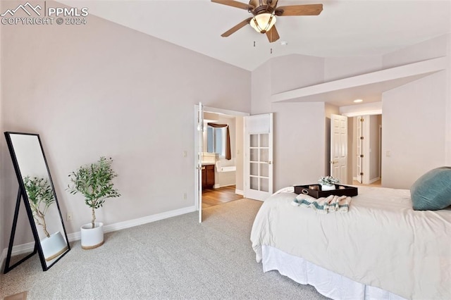 carpeted bedroom with ensuite bathroom, vaulted ceiling, and ceiling fan