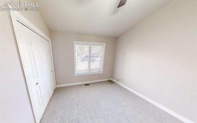 unfurnished bedroom with ceiling fan, a closet, and light carpet