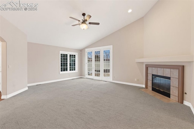 unfurnished living room featuring carpet flooring, a tile fireplace, ceiling fan, and high vaulted ceiling