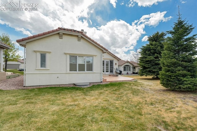 rear view of house with french doors, a yard, and a patio