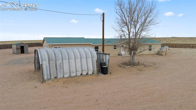 view of front of property featuring a shed