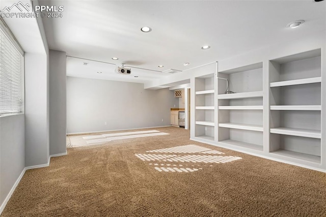 unfurnished living room featuring built in features and carpet