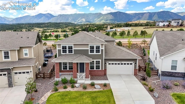 view of front of property with a mountain view, a front lawn, a porch, and a garage