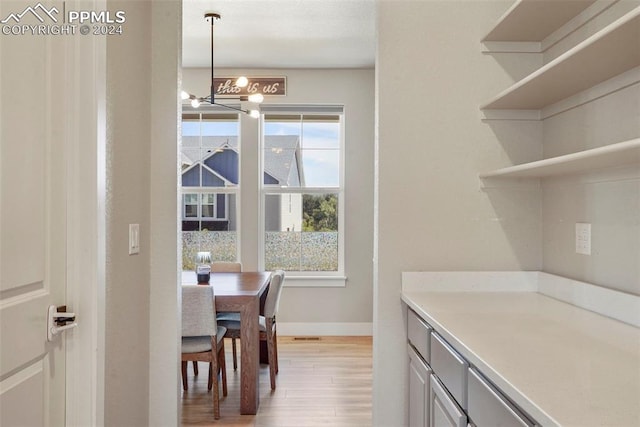 kitchen with pendant lighting, a notable chandelier, and light hardwood / wood-style floors