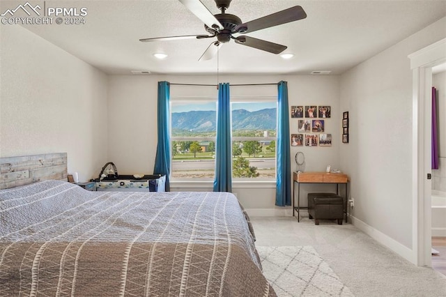 carpeted bedroom featuring a mountain view and ceiling fan