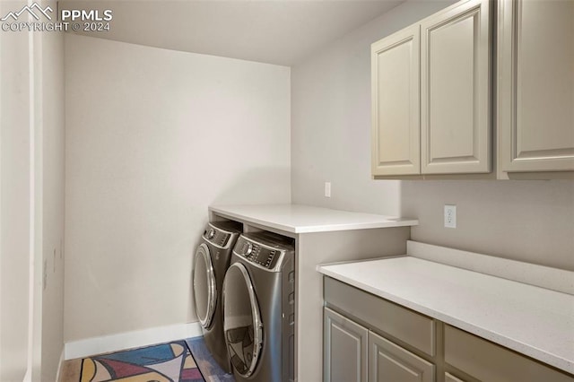 laundry room with cabinets and washing machine and clothes dryer