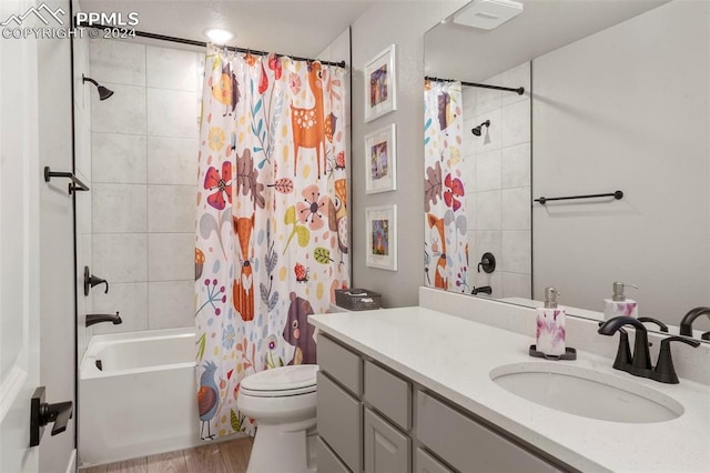 full bathroom featuring vanity, hardwood / wood-style flooring, toilet, and shower / bath combo with shower curtain