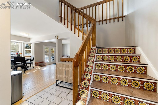 stairs with wood-type flooring and french doors