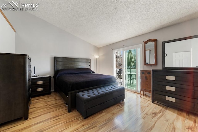 bedroom featuring a textured ceiling, vaulted ceiling, access to outside, and light hardwood / wood-style flooring