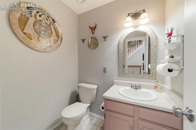 bathroom featuring tile patterned flooring, vanity, and toilet