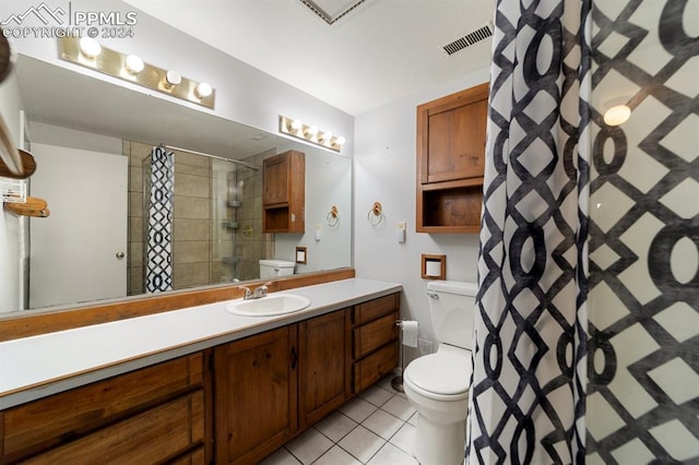 bathroom featuring tile patterned flooring, a shower with curtain, vanity, and toilet