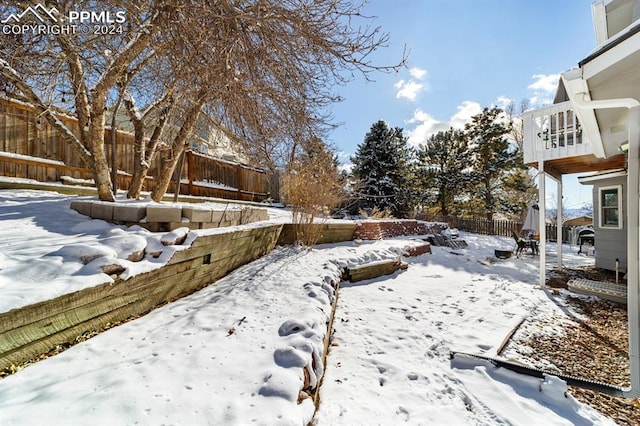 yard covered in snow with a balcony