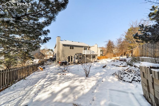 view of snow covered back of property