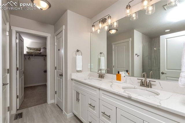 bathroom featuring a shower with door and vanity