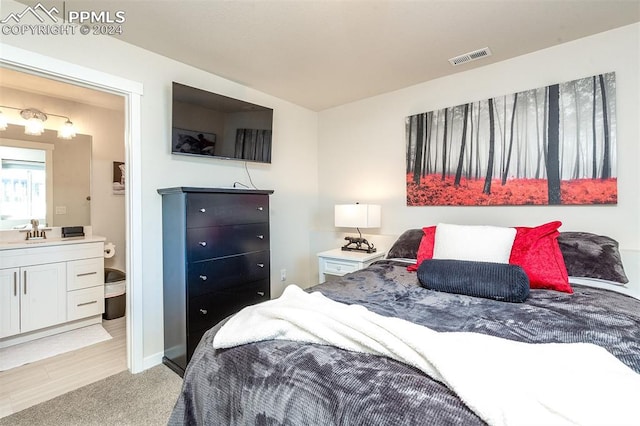 bedroom featuring light colored carpet and sink