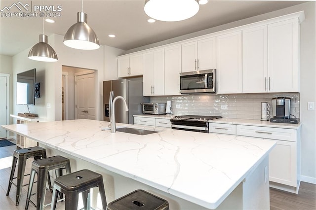 kitchen with white cabinets, an island with sink, and appliances with stainless steel finishes