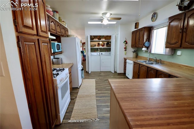 kitchen featuring ceiling fan, sink, dark hardwood / wood-style flooring, white appliances, and washer and clothes dryer