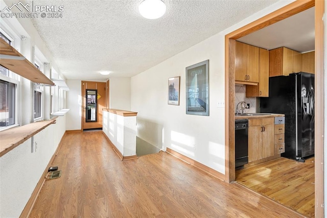 928 Alexander Rd, Colorado Springs, CO 80909 - kitchen featuring black appliances, sink, light hardwood / wood-style floors, and a textured ceiling