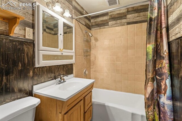 928 Alexander Rd, Colorado Springs, CO 80909 - full bathroom with shower / bath combo, wood walls, toilet, and vanity