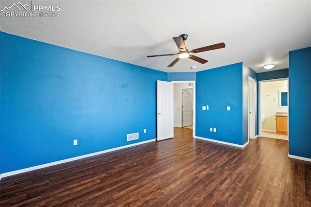 unfurnished bedroom with ceiling fan, dark hardwood / wood-style flooring, and ensuite bath