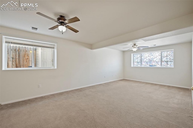 spare room featuring light carpet and ceiling fan