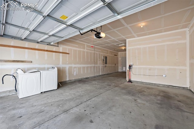 garage with independent washer and dryer, electric panel, and a garage door opener