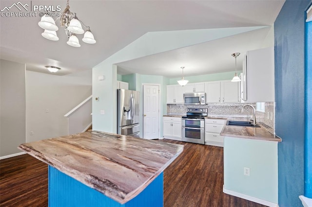 kitchen featuring backsplash, stainless steel appliances, sink, decorative light fixtures, and white cabinets