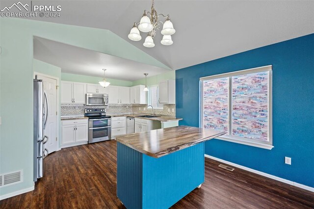 kitchen featuring white cabinets, pendant lighting, a kitchen island, and stainless steel appliances