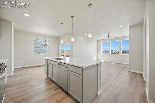 kitchen featuring stainless steel dishwasher, light hardwood / wood-style floors, sink, and an island with sink