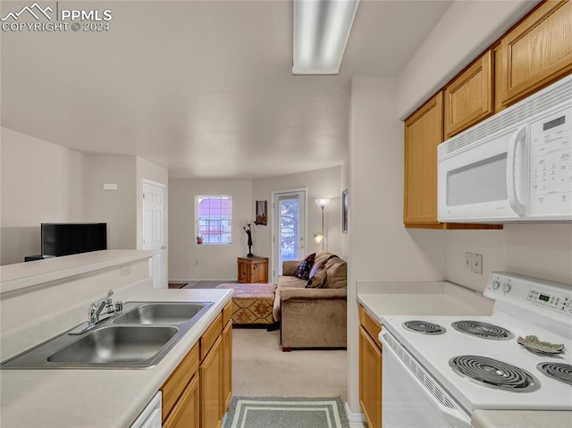 kitchen with white appliances, sink, and light carpet