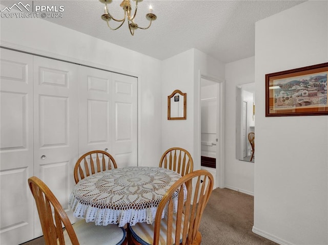 dining space featuring a textured ceiling, carpet floors, and an inviting chandelier