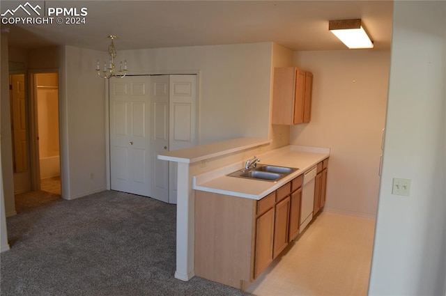 kitchen featuring kitchen peninsula, white dishwasher, light colored carpet, sink, and a chandelier