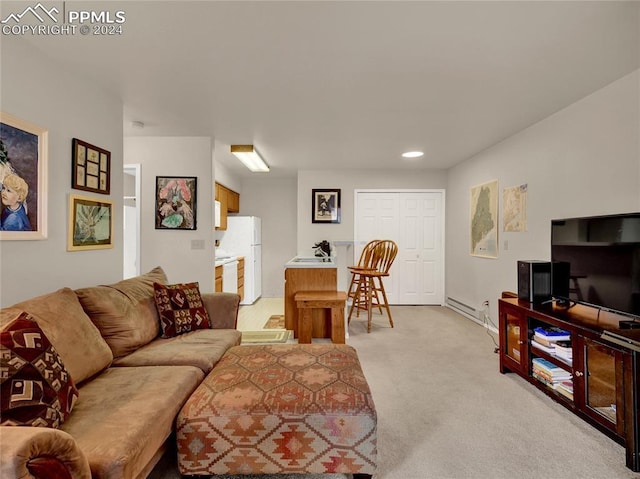 carpeted living room featuring sink and a baseboard heating unit