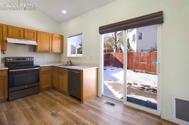 kitchen featuring appliances with stainless steel finishes, vaulted ceiling, light hardwood / wood-style flooring, and sink