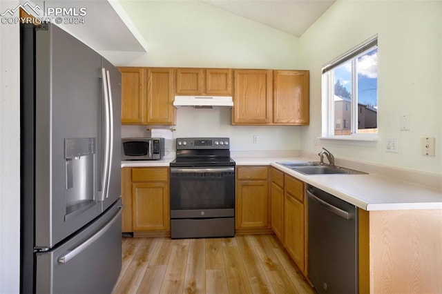 kitchen with lofted ceiling, sink, appliances with stainless steel finishes, and light hardwood / wood-style flooring