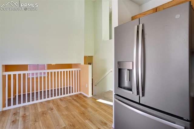 kitchen with stainless steel fridge with ice dispenser and light wood-type flooring