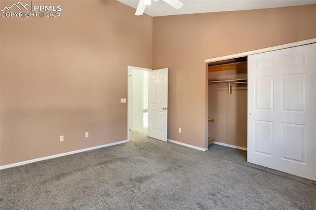 unfurnished bedroom with carpet flooring, ceiling fan, a towering ceiling, and a closet