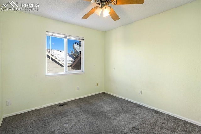 carpeted spare room featuring ceiling fan and a textured ceiling