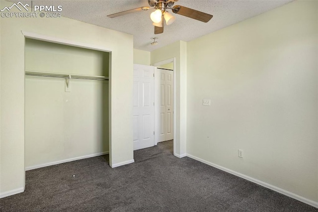 unfurnished bedroom with ceiling fan, dark carpet, and a textured ceiling