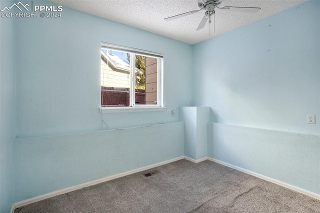 carpeted spare room with a textured ceiling and ceiling fan