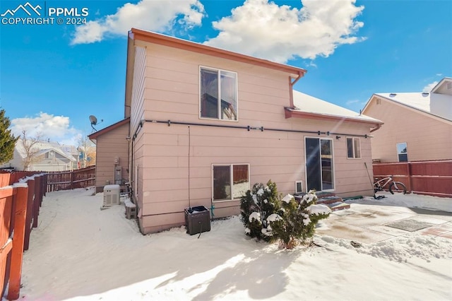 view of snow covered rear of property