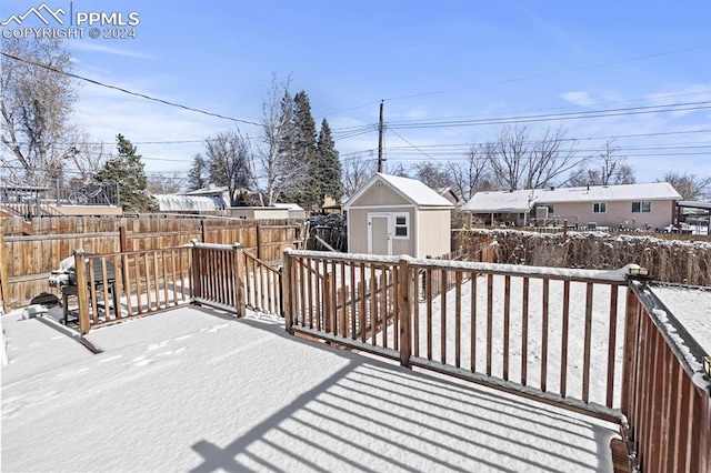 snow covered deck with a storage unit